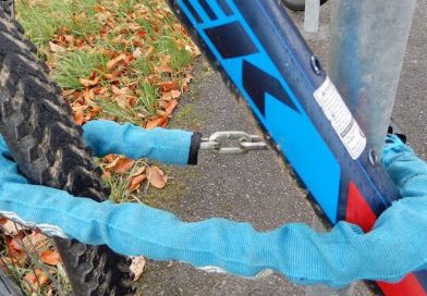 blau verkleidetes Kettenschloss an Fahrradrahmen und -vorderrad