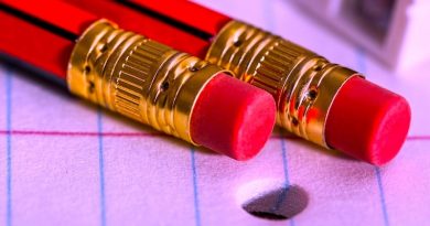 Zwei rote Bleistifte mit Radiergummi auf liniertem Papier