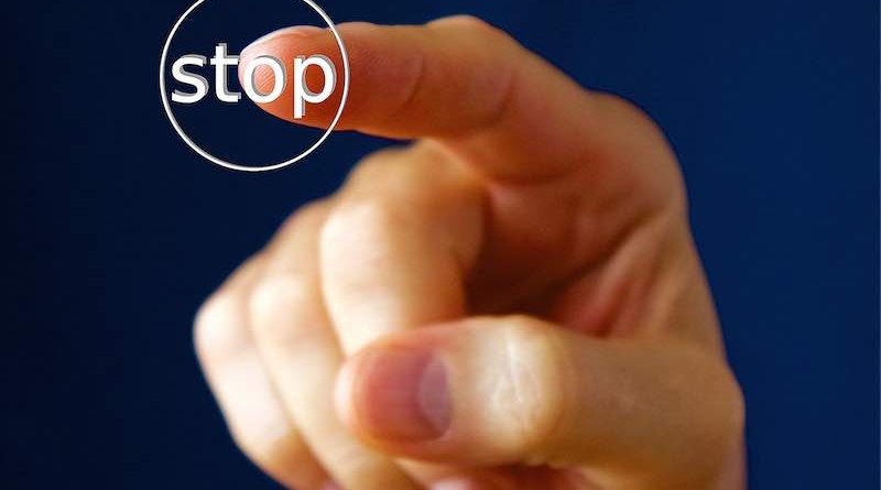Zeigefinger drückt Stop-Knopf