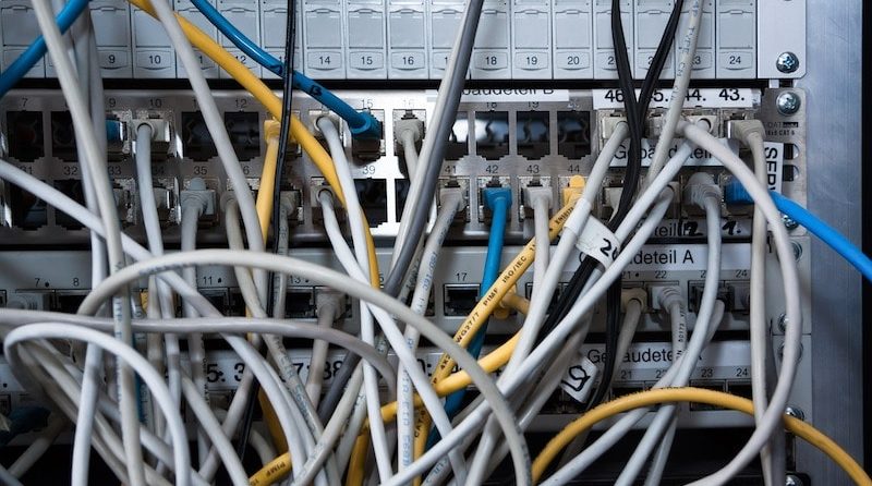 Rückseite eines Computers mit zahlreichen eingesteckten Kabeln