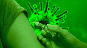 Hand beim Impfen in Oberarm vor grünem Coronasymbol
