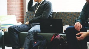 Zwei Studenten sitzen mit Laptop auf einer Bank