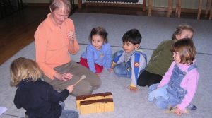 Marion Smirek mit vier kleinen Kindern beim Xylophonspiel