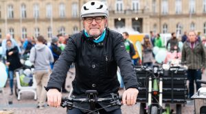 Verkehrsminister Winfried Hermann auf dem Fahrrad vor dem Neuen Schloss in Stuttgart