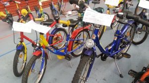 Kinderroller und -fahrräder mit Preisschildern bei einem Radbasar
