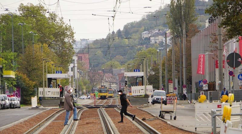 Zwei Männer kletter bei OBI über die Gleise, während von Hedelfingen die Stadtbahn naht