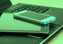 Smartphone auf Tablet auf Tastatur eines aufgeklappten Laptops