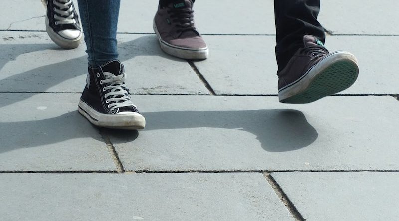 Füße von zwei Fußgängern auf Gehwegplatten