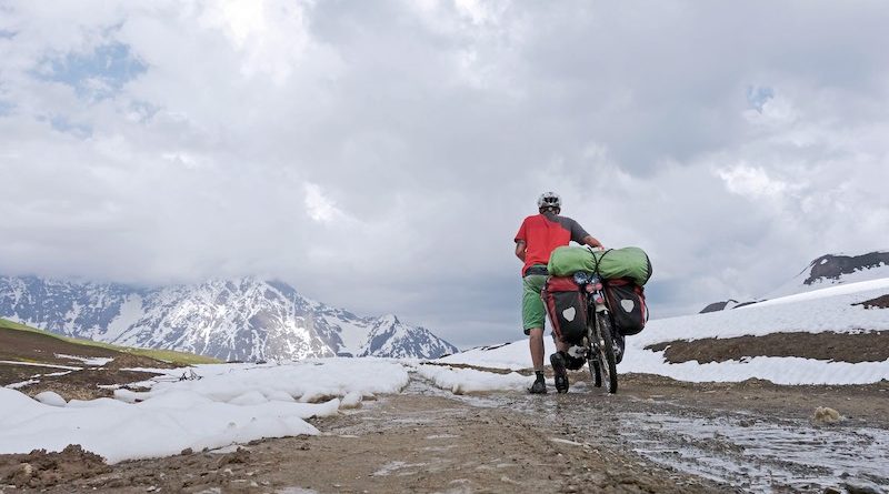Florian Keiper schiebt Fagrrad durch Schneelandschaft