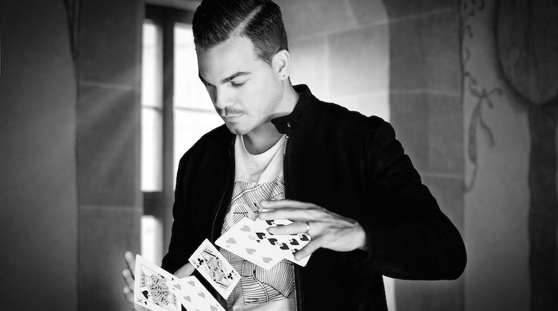 Magier Marco Miele zeigt einen Kartentrick