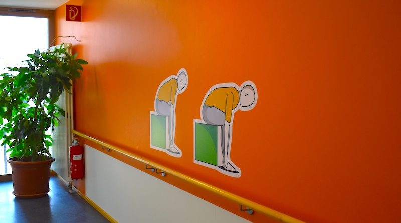 Bewegungssymbole auf oranger Wand im Willy-Körner-Haus