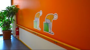 Bewegungssymbole auf oranger Wand im Willy-Körner-Haus