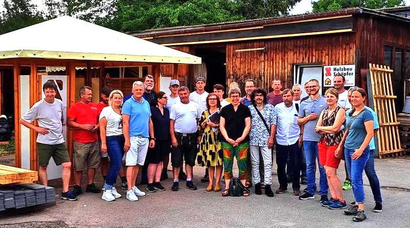 Gewerbetreibende und Bezirksbeiräte auf dem Lagerplatz von Holzbau Schöpfer am Schwarzäckerweg