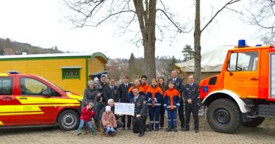 Feuerwehrler, Kindergartenvertreter und Kinder bei der Spendenübergabe
