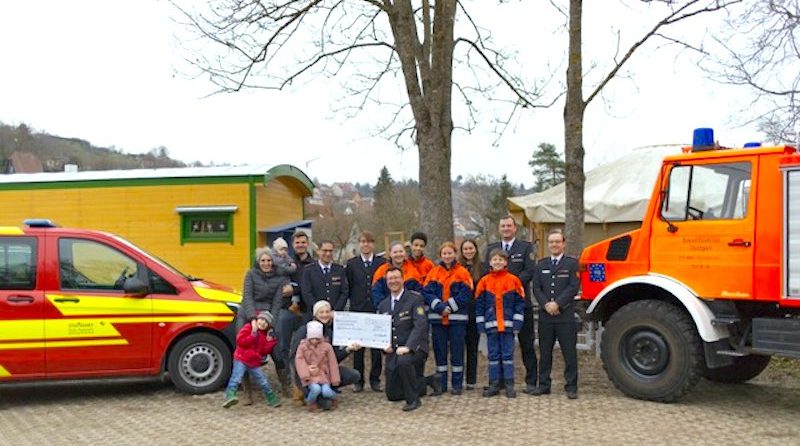 Feuerwehrler, Kindergartenvertreter und Kinder bei der Spendenübergabe