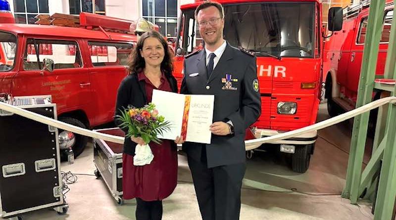 Suzana und Jan Steffen Chrobok bei Ehrung vor Feuerwehrfahrzeugen