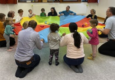 Kinder, Eltern und Musikerzieher bei einer Übung im Kreis
