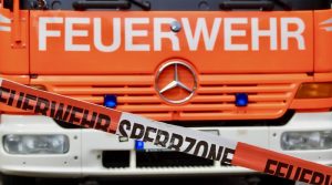 Front eines Feuerwehrfahrzeugs hinter Flatterband