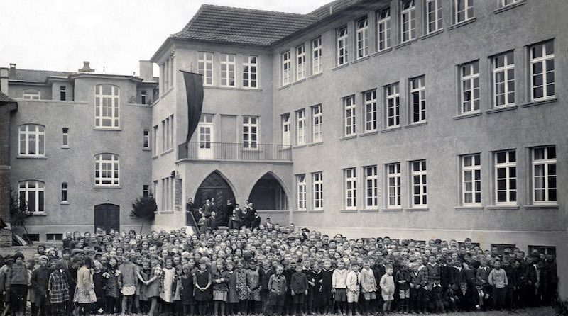 Schüler vor der neuen Schule in Hedlfingen bei deren Eröffnungsfeier 2028