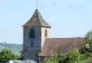 Foto der Michaelskirche in Stuttgart-Wangen bei blauem Himmel, im Hintergrund sieht man die Weinberge