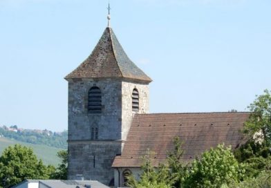 Foto der Michaelskirche in Stuttgart-Wangen bei blauem Himmel, im Hintergrund sieht man die Weinberge