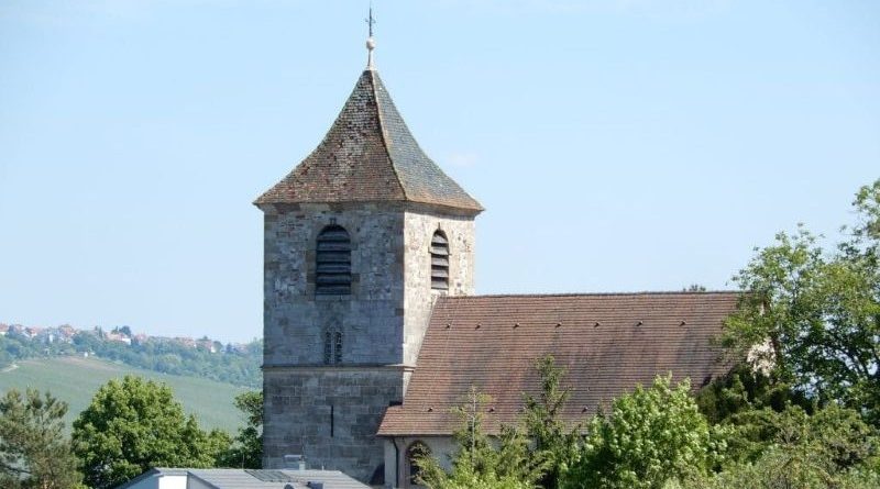 Foto der Michaelskirche in Stuttgart-Wangen bei blauem Himmel, im Hintergrund sieht man die Weinberge