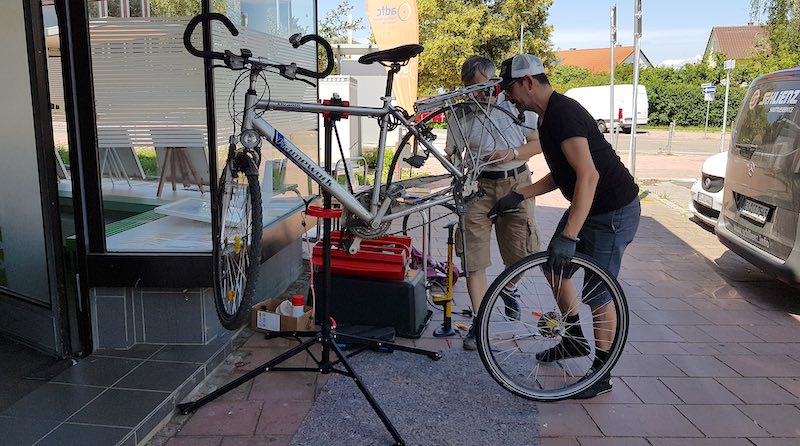 Zwei Radler arbeiten an einem Fahrrad