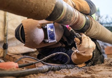 Arbeiter liegend bei Arbeiten an einer Wasserstoffleitung