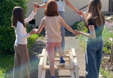 Kinder balancieren auf einem Holzgestell