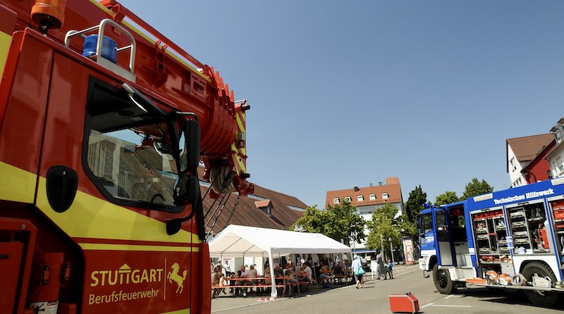 Blick zwischen Feuerwehr- und THW-Fahrzeug auf Festzelt vor der Kelter