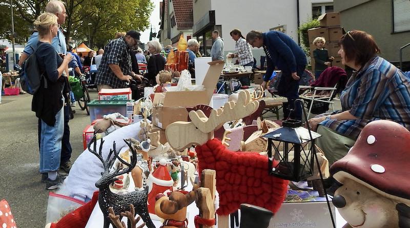 Blick über einen Flohmarkt-Stand auf die belebte Amstetter Straße beim Knausbira-Sonntag in Hedelfingen